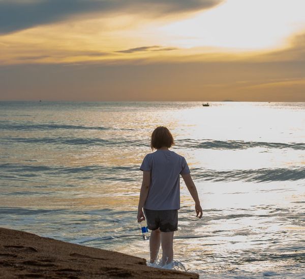 Person peacefully meditating in nature, surrounded by golden light.